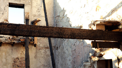 Ruins of a house after a fire, burnt house, charred ceilings, destroyed walls, garbage 