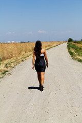 Young Teen Caucasian Girl Walking Down Gravel Road In Dress