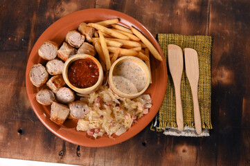 plate for food French fries sausage white sausage and sauerkraut herb sauce and ketchup typical German food