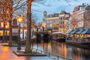 Fototapeten Leiden canal Oude Rijn with trees in Christmas illumination, South Holland, Netherlands. © Kavalenkava