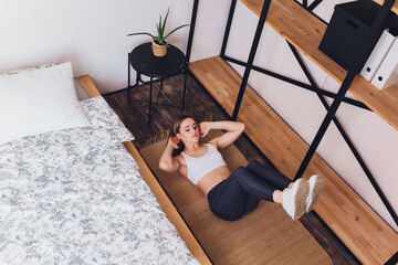 woman doing stretching exercises at home, as part of a healthy lifestyle without going to the gym.