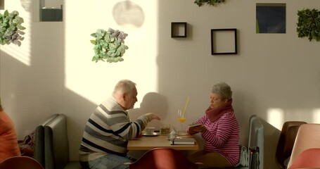 Couple in cafe. An elderly man engages in effective communication through nonviolent communication, combining verbal and nonverbal cues, converses articulately, using gestures to enhance expression.