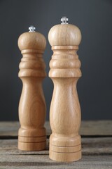 Salt and pepper shakers on wooden table, closeup