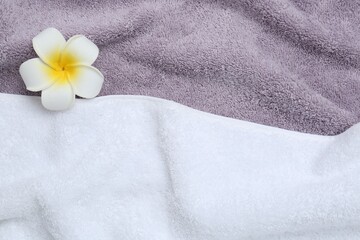 Obraz na płótnie Canvas Plumeria flower on terry towels, top view. Space for text