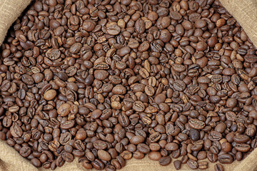 Coffee beans in a bag. Roasted aromatic natural coffee macro photo.