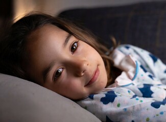 Latin little girl laying on the coach