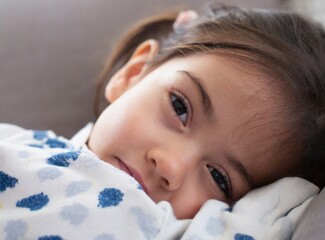 Latin little girl laying on the coach