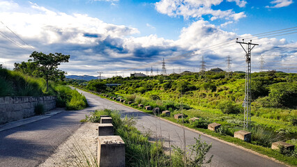Fototapeta na wymiar Road in the park, y-cross road and blue cloudy sky