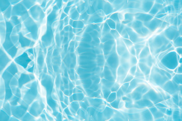 Bluewater waves on the surface ripples blurred. Defocus blurred transparent blue colored clear calm water surface texture with splash and bubbles. Water waves with shining pattern texture background.