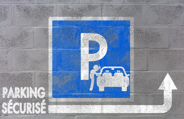Logo parking sécurisé peint sur mur de parpaings 