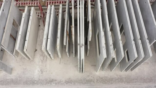Aerial top view of Precast concrete wall panel for construction building site in warehouse factory. Precast concrete manufacturing products on prefabricated house factory. 4K