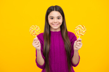 Cool teen child with lollipop over yellow isolated background. Sweet childhood life. Teen girl with...