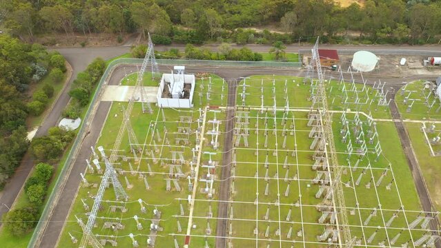 Slow sideways shot aerial drone view of a large electrical distribution substation for the generation and supply of energy to households and industry located at Picnic Point in Sydney, NSW Australia  