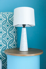 Modern lamp on wooden table near blue ocean wall with front view