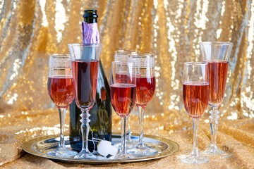 glasses of rose champagne on sparkling golden cloth