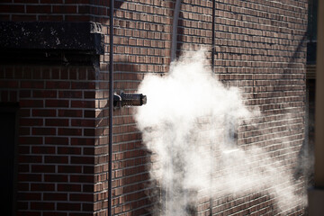Steam coming out of a central heating flue on a house wall in South Korea.