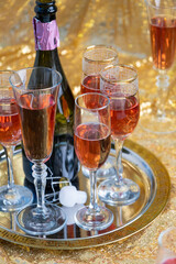 glasses of rose champagne on sparkling golden cloth