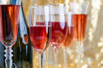 glasses of rose champagne on sparkling golden cloth