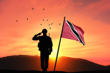 Silhouette of a soldier with the Trinidad and Tobago flag stands against the background of a sunset or sunrise. Concept of national holidays. Commemoration Day.