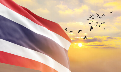 Waving flag of Thailand against the background of a sunset or sunrise. Thailand flag for Independence Day. The symbol of the state on wavy fabric. - obrazy, fototapety, plakaty