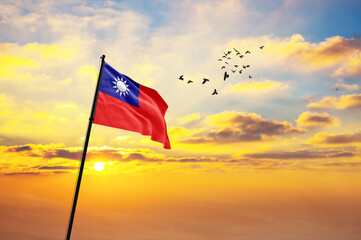 Waving flag of Taiwan against the background of a sunset or sunrise. Taiwan flag for Independence Day. The symbol of the state on wavy fabric.