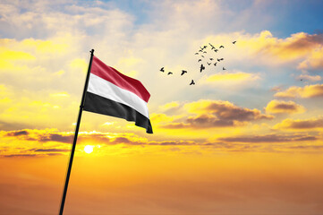 Silhouette of a soldier with the Yemen flag stands against the background of a sunset or sunrise. Concept of national holidays. Commemoration Day.