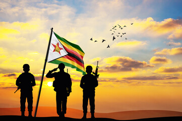 Silhouettes of soldiers with the Zimbabwe flag stand against the background of a sunset or sunrise. Concept of national holidays. Commemoration Day. - obrazy, fototapety, plakaty