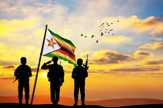 Silhouettes of soldiers with the Zimbabwe flag stand against the background of a sunset or sunrise. Concept of national holidays. Commemoration Day. - Powered by Adobe