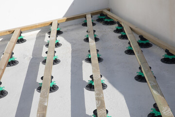 Constructing terrace wooden area on plastic piles adjustable level stud frame board in construction...