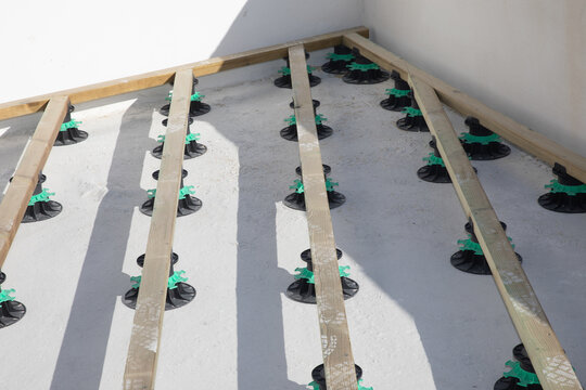 Constructing terrace wooden area on plastic piles adjustable level stud frame board in construction site