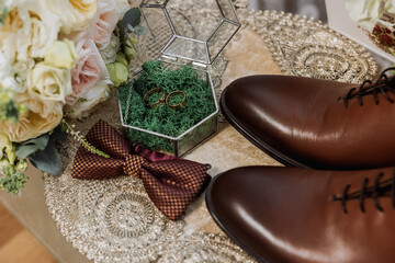 Men's accessories, groom details. Beauty is in the details. Preparation for the Wedding. Leather shoes. Gold wedding rings. Bow tie. Wedding bouquet of flowers.