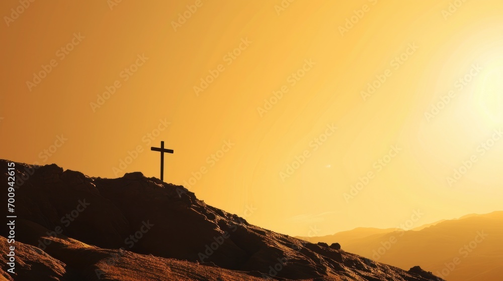 Poster a cross on top of a hill with the sun setting in the backgrouund of the mountain behind it.