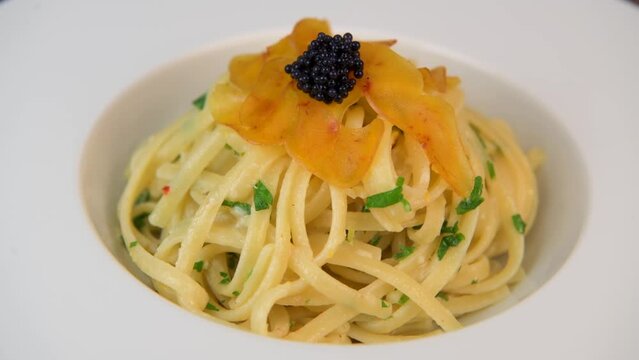 LINGUINE PASTA RECIPE WITH POUTARGUE, LEMON, GARLIC, LEMON ZEST, FRESH CREAM AND PARSLEY. High quality 4k footage