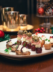 Fotografías de una cena de navidad con elementos navideños como bolas de navidad, pino y velas....