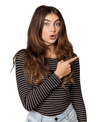 Young Caucasian woman in studio setting pointing to the side