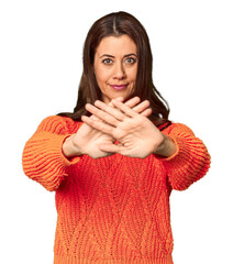 Elegant middle-aged Caucasian woman in studio setting doing a denial gesture