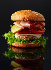 Burger on a black reflective background.
