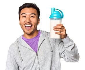 Fit Chinese male with protein shake and bottle in studio setup