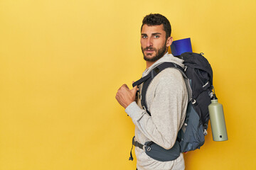 Young Hispanic man with canteen and backpack