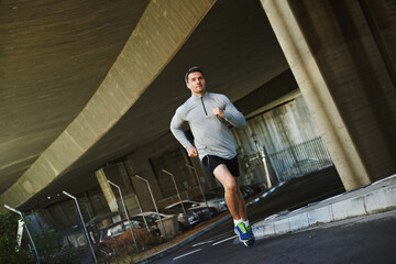 Man, runner and exercise on road in outdoor, cardio and fitness or training for marathon. Male person, athlete and workout by city background, sportswear and performance challenge by bridge on street