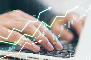 Close up of male hands using laptop with growing upward chart, map, arrows and forex graph on...