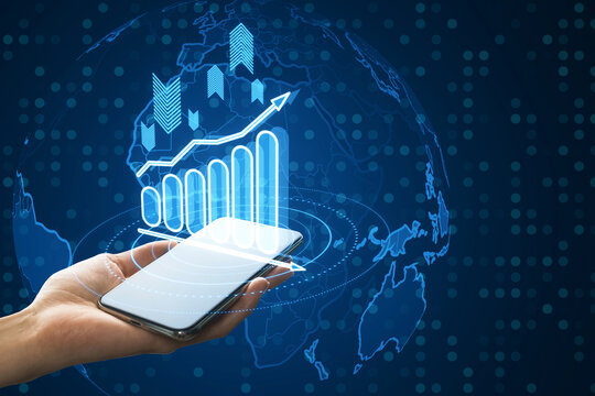 Close up of female hand holding mobile phone with glowing business chart with globe hologram on blurry background. Financial plan graph. - Powered by Adobe