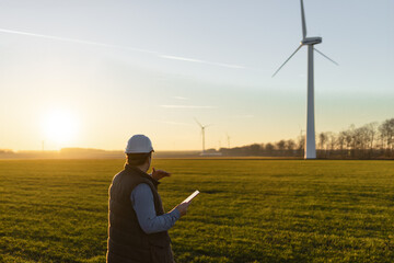 Businessman checking on wind turbine energy production