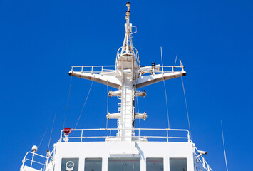 Mast of a cargo ship with navigation equipment bottom view. Radar, signal beeps and signal lights.