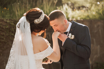 Wedding. Love and couple in garden for wedding. Celebration of ceremony and commitment. Save the date. Trust. The bride and groom embrace. Smile and love. The groom embraces the bride at sunset.