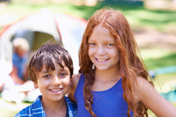 Camping, children and relaxing in portrait while outside, bonding and happy for outdoor adventure. Kids, face and smiling together on holiday, friendship and vacation in nature, childhood and grass