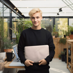 blonde man standing front on holding a plain black laptop sleeve, office setting, photo realistic