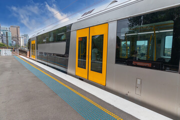Commuter Train fast moving through a Station in Sydney NSW Australia locomotive electric light rail