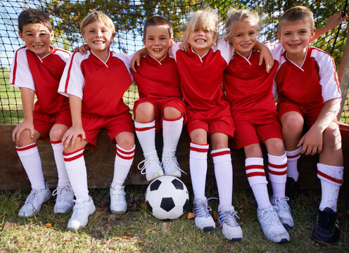 Kids, soccer team and portrait with ball, boys and girls with players, support or solidarity. Energy, sports and friendship, together and happy for win, ready for game or physical activity