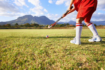 Person, green grass and playing hockey for game, outdoor match or sports in nature for practice....